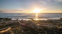 Epic sunset over ocean in Koitiata beach with old drift wood in New Zealand wild nature Time lapse
