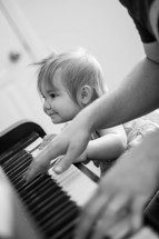 Baby girl learns to play piano with her dad.  Learning to worship.