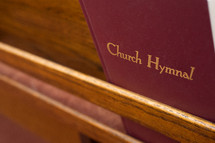 Hymnal on the back of a church pew.
