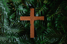cross in a pile of palm leaves 