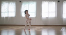 Little girl dancing alone in a studio