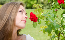 A woman smelling the roses. 
