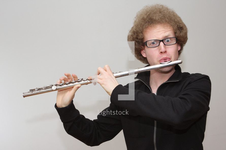 A man in glasses playing a flute.