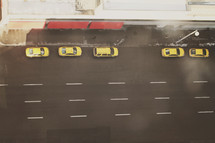 a row of yellow cabs from above in the downtown streets