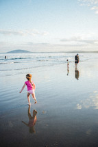 A family walking on wet sand at the beach 