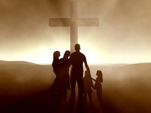 Silhouette of a family around the cross at dusk.