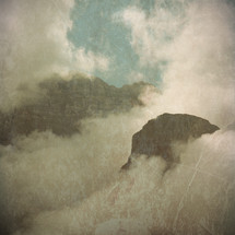tops of mountains engulfed in low clouds - textured for vintage look