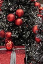 Silver and red Christmas decor and a wrapped gift.