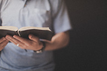 Hands holding an open bible. 