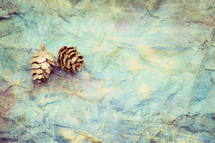 pine cone on blue green crinkled background 