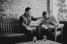 men praying and reading Bibles at a Bible study 