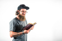 man with tattoos reading a Bible 