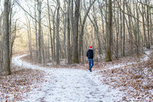 a man in a Santa hat walking on a snowy path 
