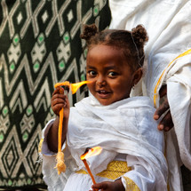 little girl holding flames at a celebration in Ethiopia 