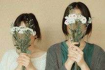 girls holding bouquets of daisies 
