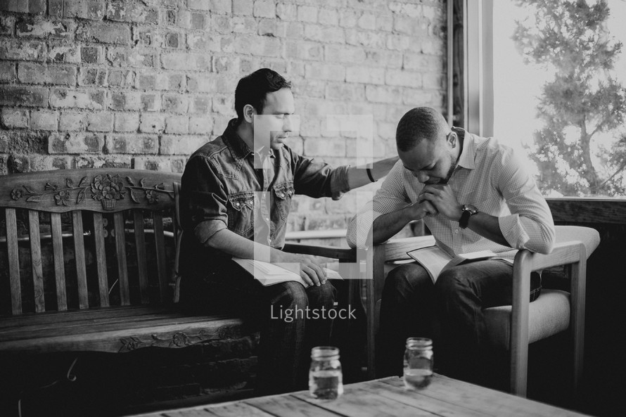 men praying and reading Bibles at a Bible study 