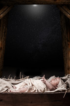 baby Jesus under the stars in a manger 