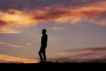 man silhouette in the countryside and sunset background