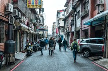 people walking on a narrow street in Taiwan 