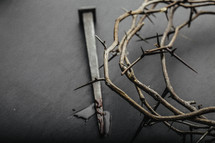 A crown of thorns and a nail with blood on it.
