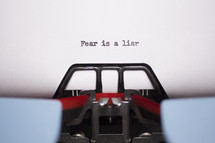 word fear is a liar typed on paper by a typewriter 