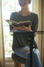 A smiling young woman leading a Bible study.