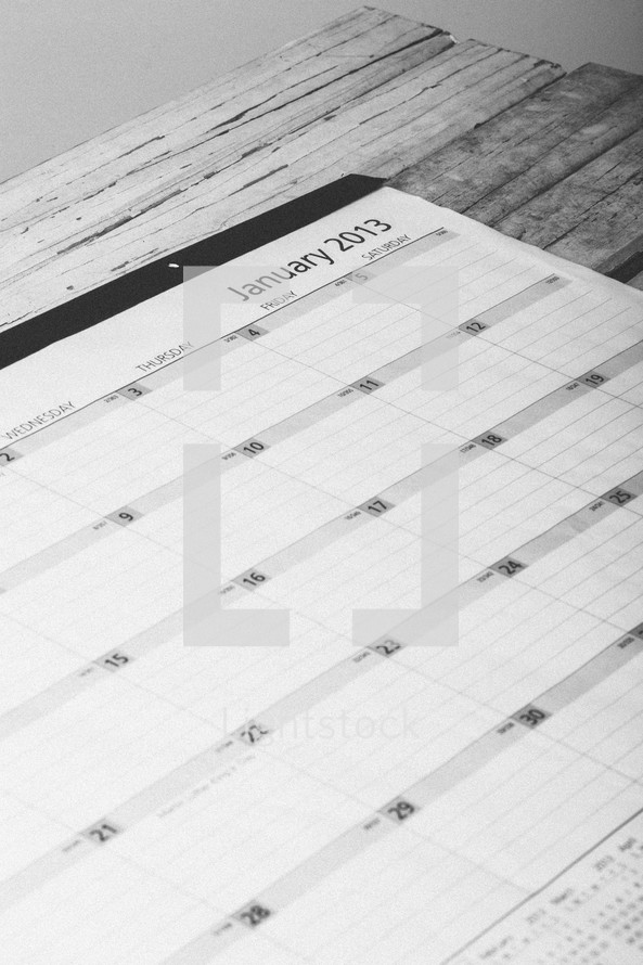 Day planner open to January 2013 on wooden table.