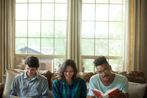 Young people sitting on a couch at a home Bible study.