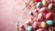 Colorful easter eggs and spring flowers on a pink background.
