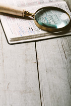 magnifying glass on the pages of a Bible - searching for clarity