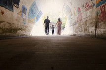 a young family walking through a tunnel 