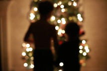 children standing in front of a Christmas tree 