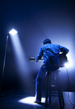 Light shines on a guitarist on stage