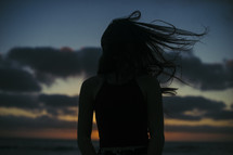 silhouette of a woman tossing her hair 