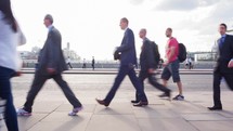 pedestrians walking across London Bridge 