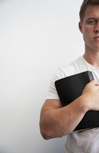 man holding a Bible to his chest 