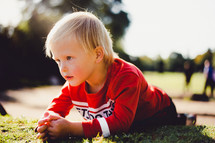toddler laying in grass 