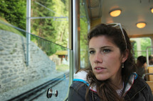 woman sitting on a cable car looking out a window