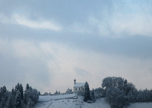 distant church on top of a snowy hill 