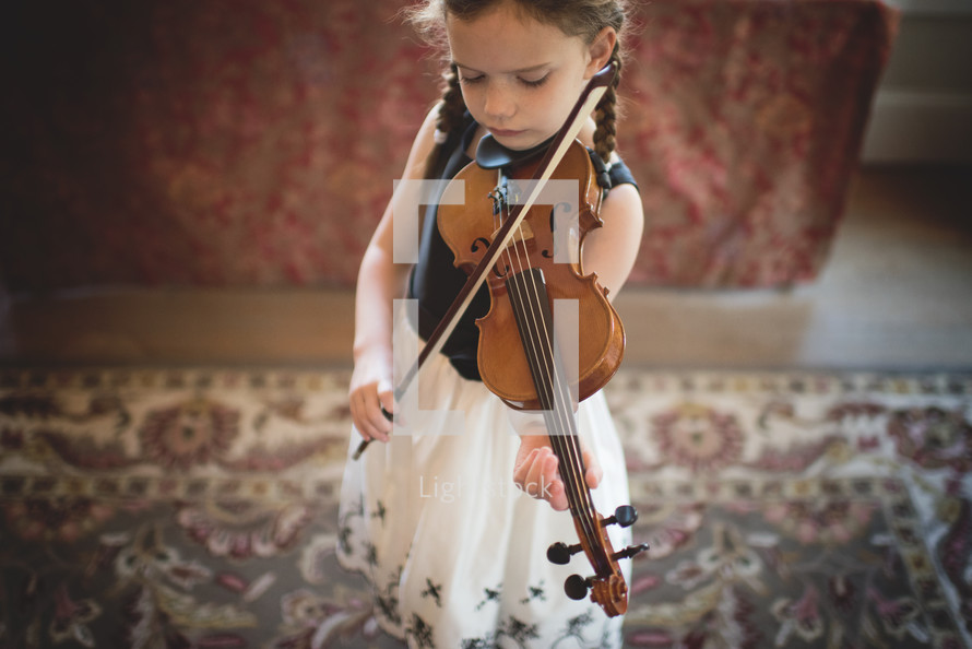 a girl child practicing her violin 