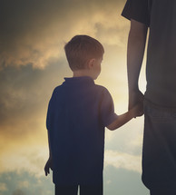 father holding his son's hand 