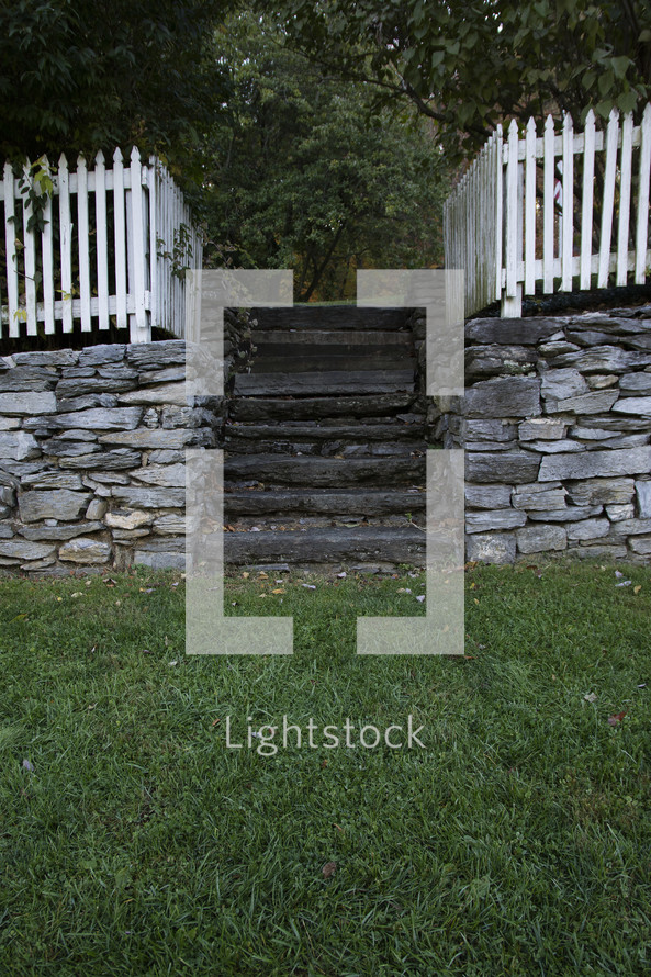 white picket fence at the top of a stone wall