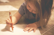 a toddler writing with a pen 