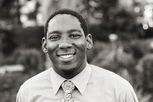 A smiling young man in a shirt and tie African American 