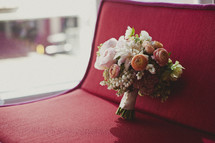 A bouquet of flowers resting on a red couch