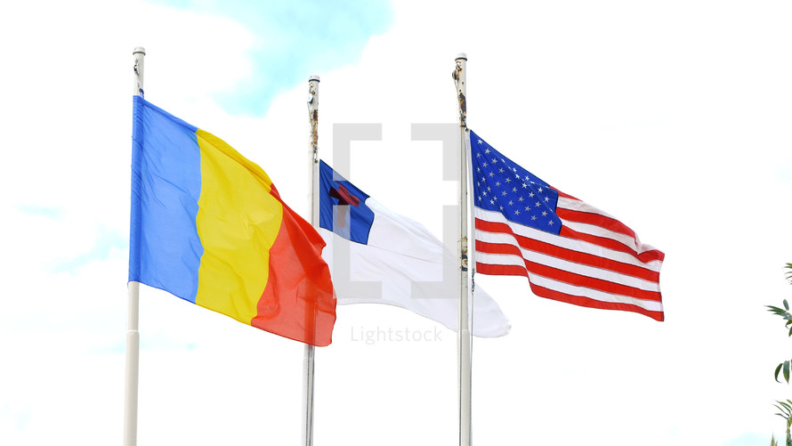 Romanian, American, and Christian flags on flag poles 