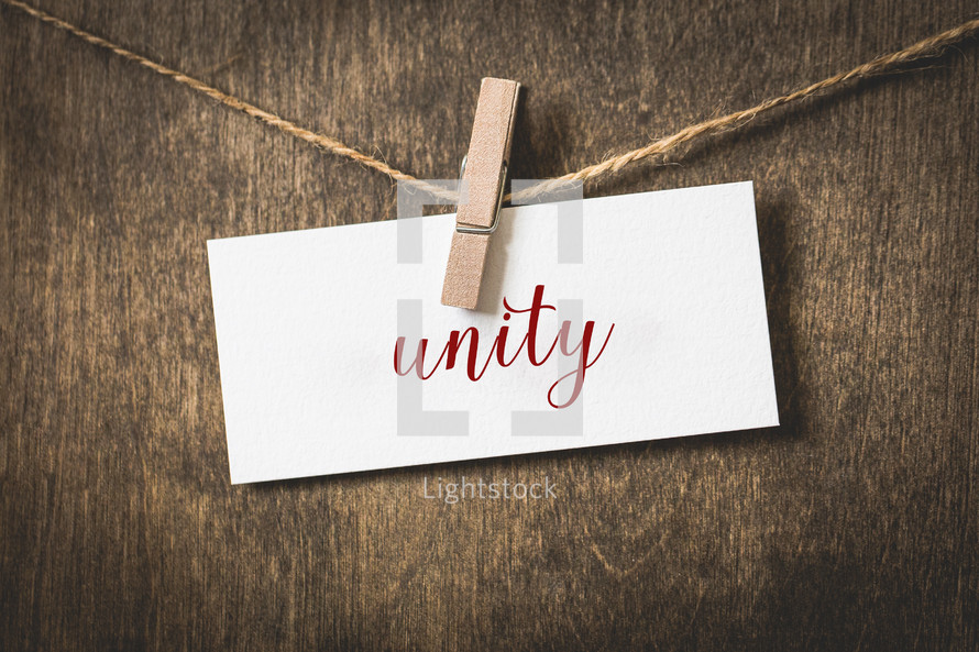 word unity on white card stock hanging from a clothespin on a clothesline 