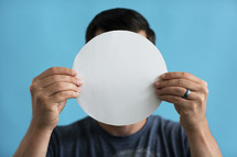 a man holding up a blank piece of paper
