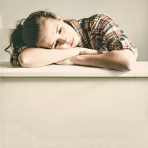 a teen girl with her head on her desk 
