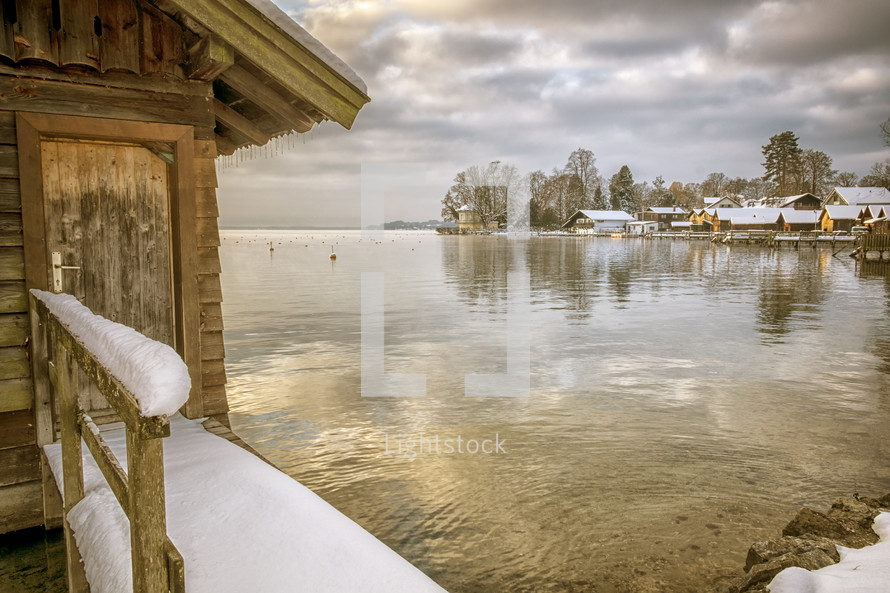 snow and ice on a boathouse on a lake in winter 